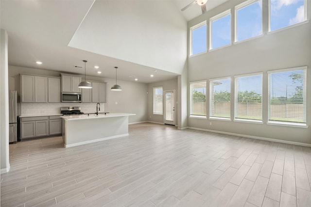 4805 Magnolia Springs Dr, Pearland, TX 77584 - kitchen with stainless steel appliances, gray cabinets, open floor plan, recessed lighting, and decorative backsplash