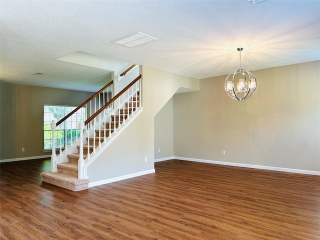 2802 Grants River Cir, Sugar Land, TX 77479 - unfurnished room featuring stairs, wood finished floors, a chandelier, and a textured ceiling