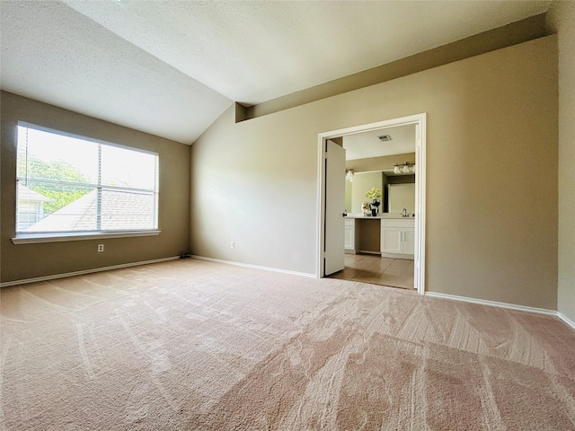 2802 Grants River Cir, Sugar Land, TX 77479 - unfurnished bedroom featuring carpet flooring, vaulted ceiling, ensuite bath, and a textured ceiling