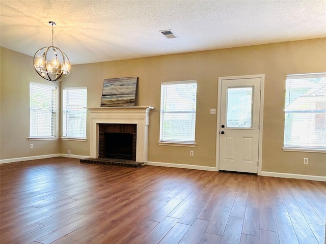 2802 Grants River Cir, Sugar Land, TX 77479 - unfurnished living room with a chandelier, dark wood finished floors, plenty of natural light, and a textured ceiling