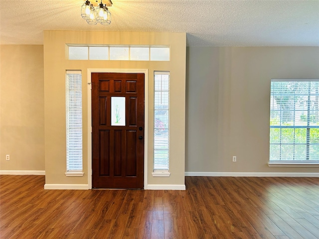 2802 Grants River Cir, Sugar Land, TX 77479 - foyer entrance with dark wood-type flooring, a chandelier, and a textured ceiling