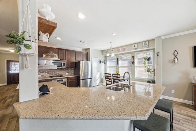 2209 Valley Blossum Ln, League City, TX 77573 - kitchen with stainless steel appliances, decorative backsplash, light wood-style flooring, light stone counters, and recessed lighting