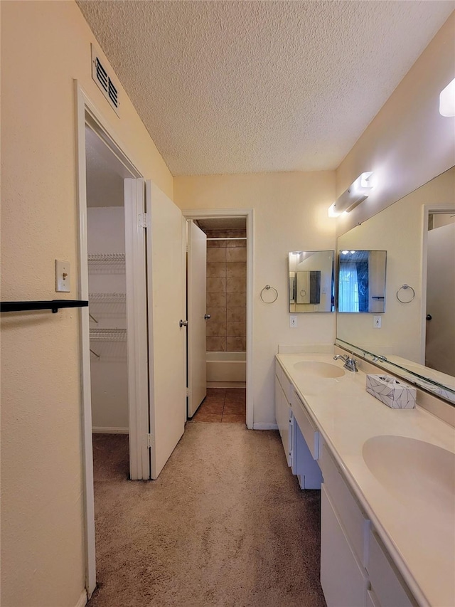1515 Sandy Springs Rd Unit 1903, Houston, TX 77042 - bathroom with a textured ceiling and double vanity