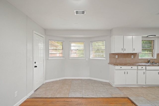 2931 Barksdale Dr, Houston, TX 77093 - kitchen with plenty of natural light, white cabinets, decorative backsplash, and light wood-type flooring