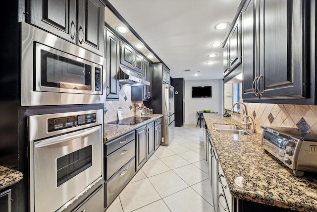 3350 Mccue Rd Unit 1504, Houston, TX 77056 - kitchen with appliances with stainless steel finishes, backsplash, stone countertops, and dark cabinetry