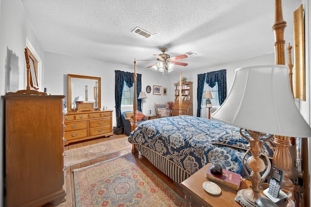 2970 Spanish Oaks Dr, Brenham, TX 77833 - bedroom with wood finished floors, a textured ceiling, and a ceiling fan