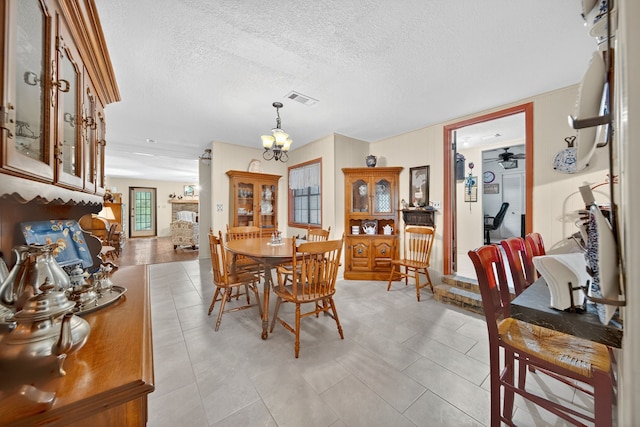 2970 Spanish Oaks Dr, Brenham, TX 77833 - dining space with a chandelier, a textured ceiling, light tile patterned floors, and ceiling fan