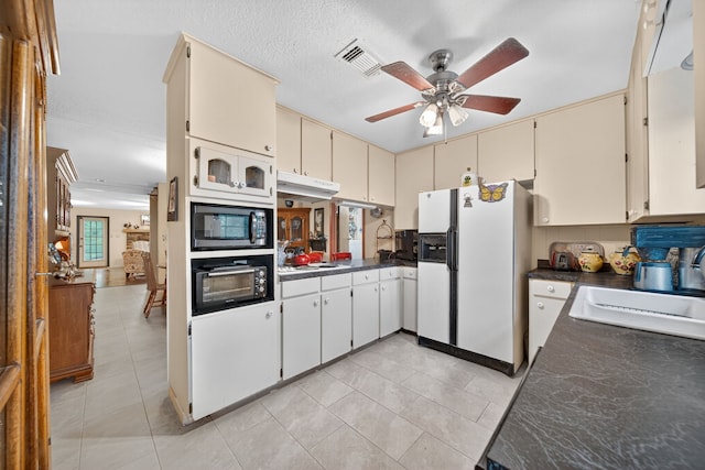 2970 Spanish Oaks Dr, Brenham, TX 77833 - kitchen featuring white refrigerator with ice dispenser, cream cabinetry, dark countertops, and light tile patterned floors