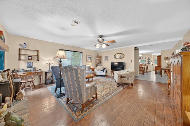2970 Spanish Oaks Dr, Brenham, TX 77833 - living area featuring a ceiling fan, a textured ceiling, wood-type flooring, and ornamental molding