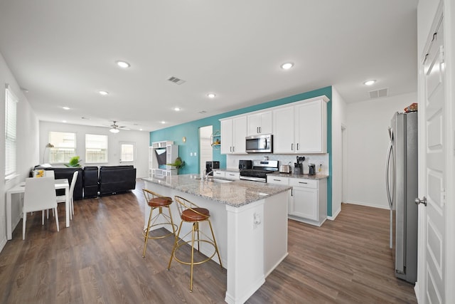 5958 First Blush Dr, Katy, TX 77493 - kitchen featuring stainless steel appliances, ceiling fan, white cabinets, dark wood-type flooring, and recessed lighting