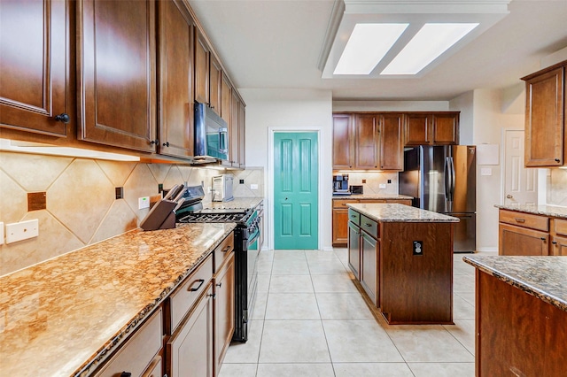 2961 Autumn Brook Ln, League City, TX 77573 - kitchen featuring stainless steel appliances, decorative backsplash, light stone countertops, and light tile patterned floors