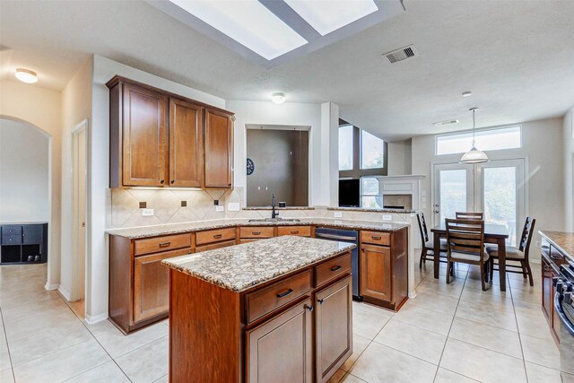2961 Autumn Brook Ln, League City, TX 77573 - kitchen featuring dishwashing machine, decorative backsplash, brown cabinets, and a fireplace