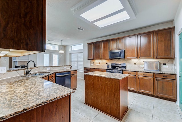 2961 Autumn Brook Ln, League City, TX 77573 - kitchen featuring stainless steel appliances, light stone countertops, decorative backsplash, a peninsula, and a center island