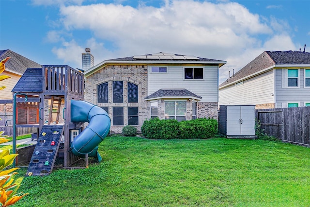 2961 Autumn Brook Ln, League City, TX 77573 - back of house with brick siding, a playground, a shed, roof mounted solar panels, and a fenced backyard