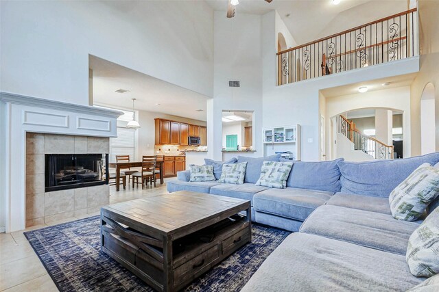 2961 Autumn Brook Ln, League City, TX 77573 - living area with a ceiling fan, high vaulted ceiling, arched walkways, light tile patterned floors, and stairs