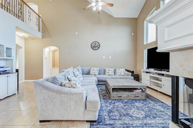 2961 Autumn Brook Ln, League City, TX 77573 - living room featuring a high ceiling, arched walkways, a ceiling fan, and light tile patterned flooring