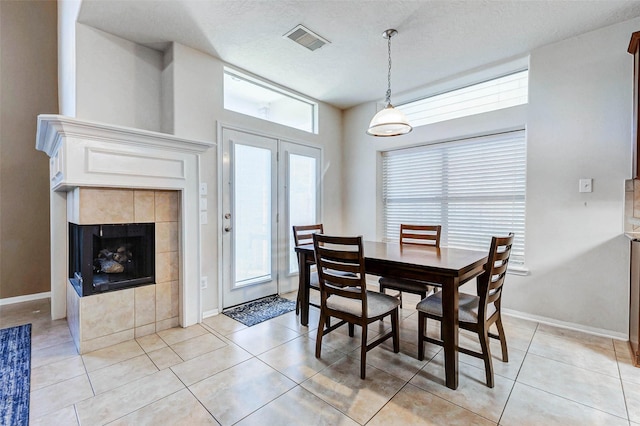 2961 Autumn Brook Ln, League City, TX 77573 - dining room with light tile patterned floors, a tile fireplace, and a textured ceiling