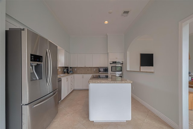 11914 Ashmead Dr, Houston, TX 77077 - kitchen with appliances with stainless steel finishes, white cabinets, decorative backsplash, ornamental molding, and a center island