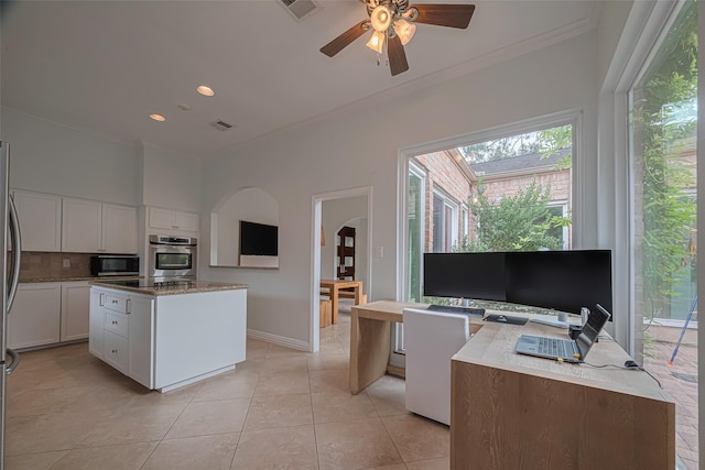 11914 Ashmead Dr, Houston, TX 77077 - kitchen with stainless steel microwave, ornamental molding, white cabinets, plenty of natural light, and a center island