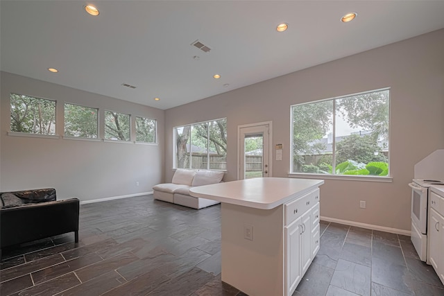 11914 Ashmead Dr, Houston, TX 77077 - kitchen with white range with electric stovetop, light countertops, open floor plan, white cabinetry, and recessed lighting