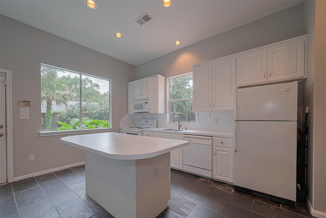 11914 Ashmead Dr, Houston, TX 77077 - kitchen with white appliances, light countertops, white cabinets, recessed lighting, and a center island