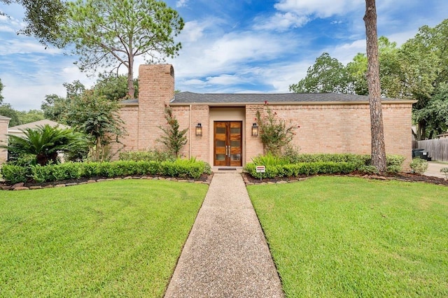11914 Ashmead Dr, Houston, TX 77077 - mid-century home featuring french doors, a front yard, brick siding, and a chimney