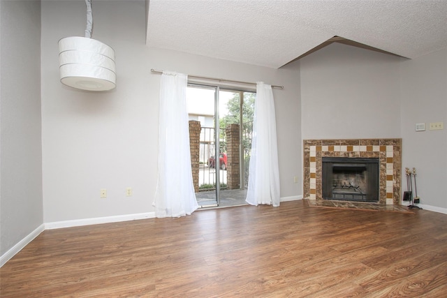 10615 Briar Forest Dr Unit 402, Houston, TX 77042 - unfurnished living room with a textured ceiling, wood finished floors, and a tiled fireplace