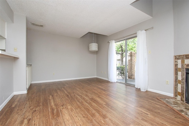 10615 Briar Forest Dr Unit 402, Houston, TX 77042 - unfurnished living room with a fireplace, wood finished floors, and a textured ceiling
