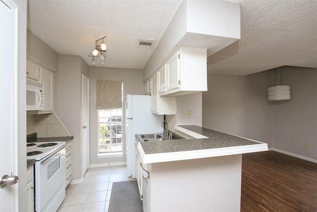 10615 Briar Forest Dr Unit 402, Houston, TX 77042 - kitchen featuring white appliances, a textured ceiling, white cabinets, backsplash, and a peninsula