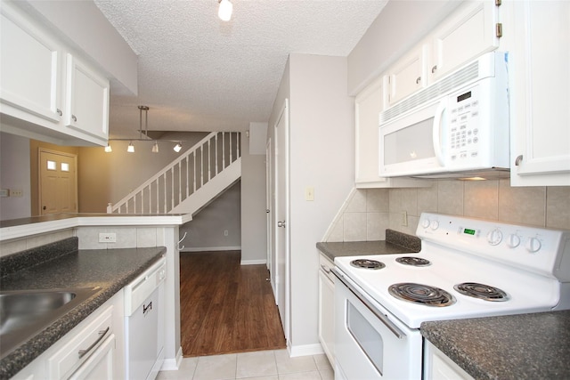 10615 Briar Forest Dr Unit 402, Houston, TX 77042 - kitchen featuring white appliances, white cabinetry, tasteful backsplash, a textured ceiling, and light tile patterned flooring