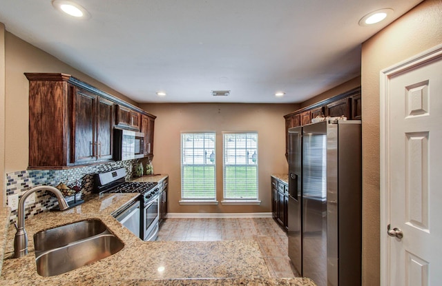 2516 Vaughn St, Houston, TX 77093 - kitchen featuring appliances with stainless steel finishes, dark brown cabinets, light stone counters, decorative backsplash, and recessed lighting