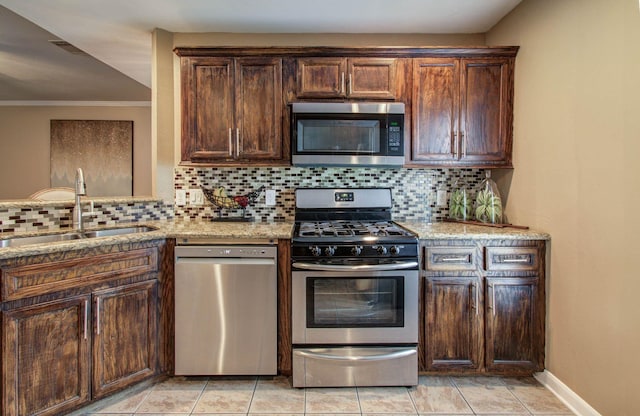 2516 Vaughn St, Houston, TX 77093 - kitchen featuring appliances with stainless steel finishes, backsplash, light stone counters, crown molding, and dark brown cabinets