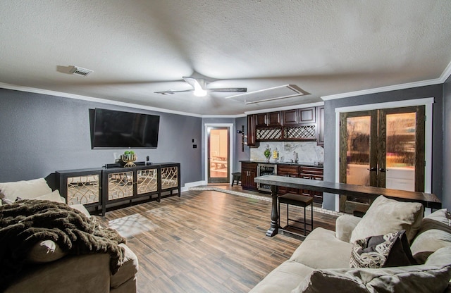 2516 Vaughn St, Houston, TX 77093 - living area with a ceiling fan, ornamental molding, wine cooler, wet bar, and wood finished floors