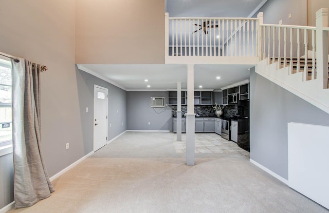 2516 Vaughn St, Houston, TX 77093 - unfurnished living room with light colored carpet, a high ceiling, a wall unit AC, and stairs