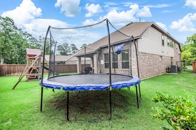 7906 Pershing Ave, Magnolia, TX 77354 - back of house with a trampoline, a fenced backyard, brick siding, and a playground