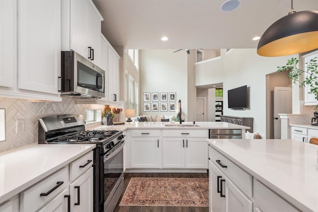 7906 Pershing Ave, Magnolia, TX 77354 - kitchen with appliances with stainless steel finishes, light countertops, white cabinetry, dark wood-style flooring, and recessed lighting