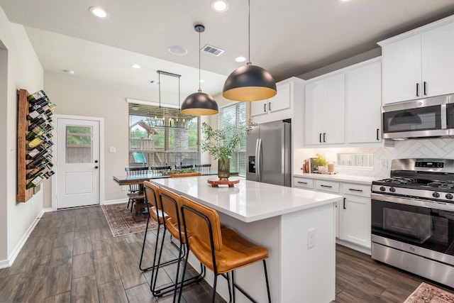 7906 Pershing Ave, Magnolia, TX 77354 - kitchen featuring stainless steel appliances, recessed lighting, decorative backsplash, light countertops, and a center island