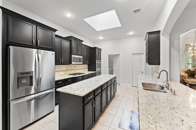 6 Inland Prairie Dr, Tomball, TX 77375 - kitchen with stainless steel appliances, a center island, dark cabinets, a skylight, and recessed lighting