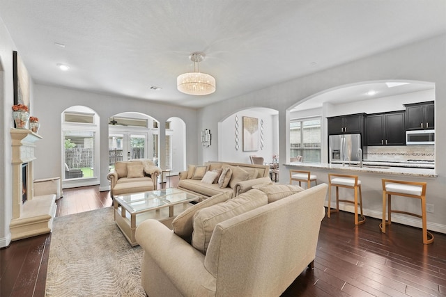 6 Inland Prairie Dr, Tomball, TX 77375 - living room featuring arched walkways, dark wood-style flooring, and a high end fireplace