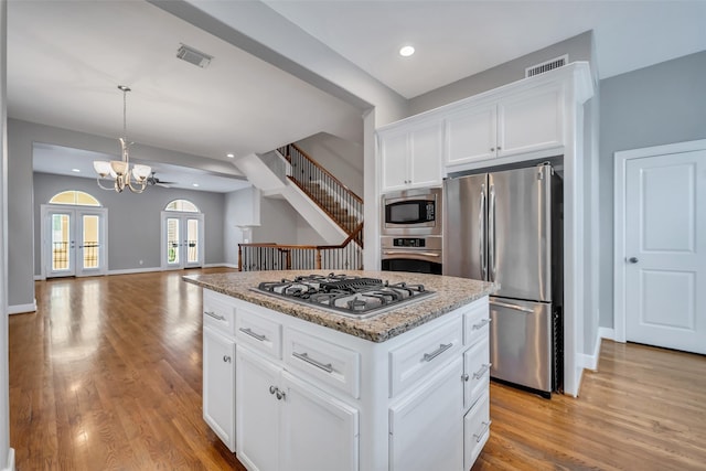 542 Bomar St, Houston, TX 77006 - kitchen with appliances with stainless steel finishes, light wood-style floors, a chandelier, white cabinets, and recessed lighting