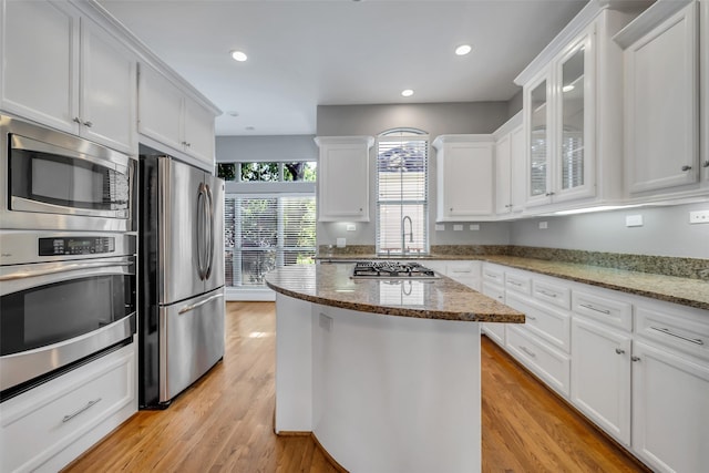 542 Bomar St, Houston, TX 77006 - kitchen featuring appliances with stainless steel finishes, white cabinets, light wood-type flooring, and recessed lighting