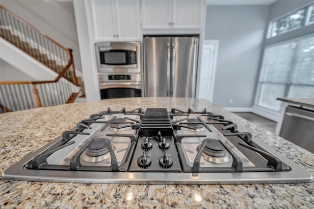 542 Bomar St, Houston, TX 77006 - kitchen view of appliances with stainless steel finishes, light stone countertops, and white cabinets