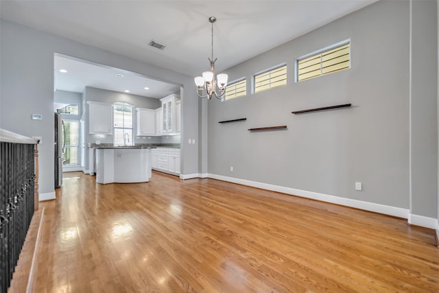 542 Bomar St, Houston, TX 77006 - kitchen with a chandelier, white cabinetry, light wood-style flooring, pendant lighting, and a kitchen island