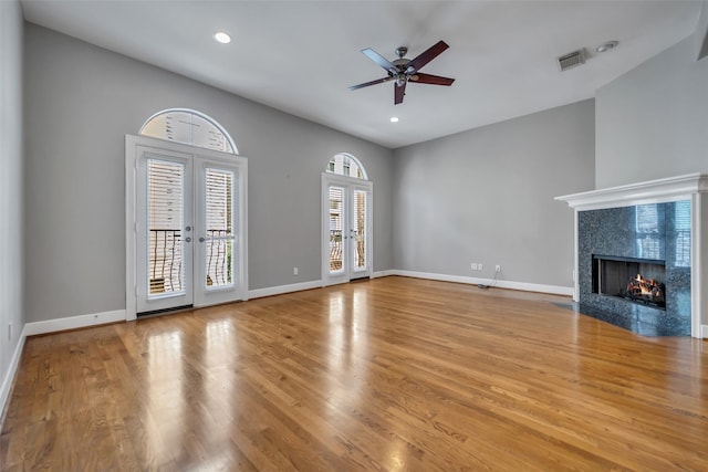 542 Bomar St, Houston, TX 77006 - unfurnished living room featuring a high end fireplace, ceiling fan, wood finished floors, recessed lighting, and french doors