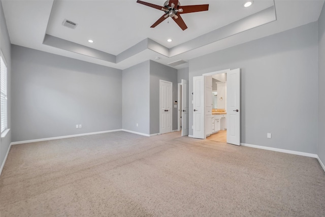 542 Bomar St, Houston, TX 77006 - unfurnished bedroom with a tray ceiling, light carpet, recessed lighting, and connected bathroom