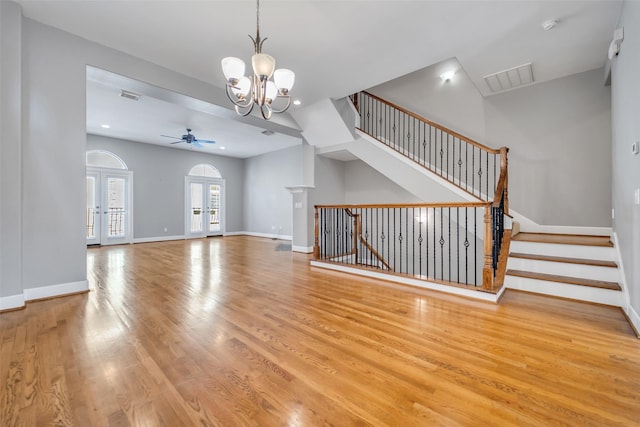542 Bomar St, Houston, TX 77006 - unfurnished living room with french doors, wood finished floors, a chandelier, stairway, and recessed lighting