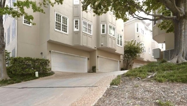 2006 Buffalo Ter, Houston, TX 77019 - view of front of property featuring an attached garage, stucco siding, and driveway