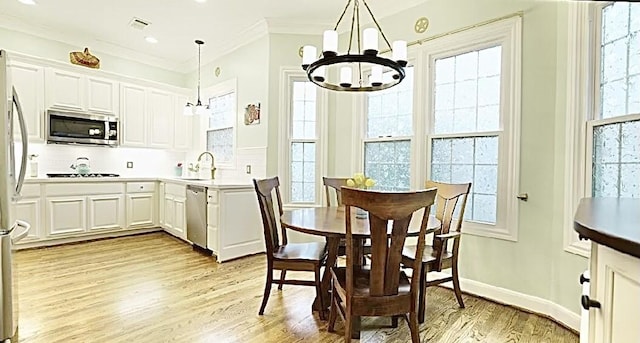 2006 Buffalo Ter, Houston, TX 77019 - dining area with a chandelier, light wood-style flooring, plenty of natural light, and ornamental molding