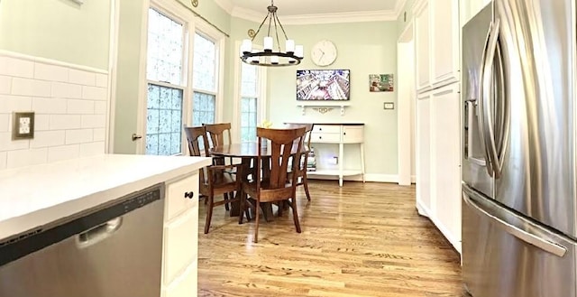 2006 Buffalo Ter, Houston, TX 77019 - dining room with a chandelier, ornamental molding, and light wood-style flooring