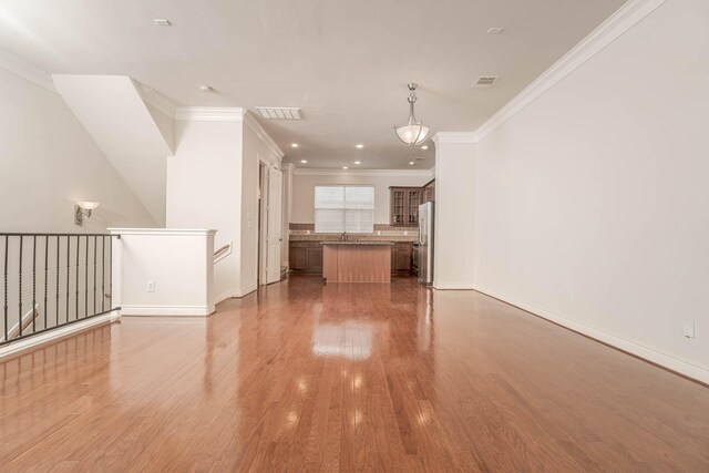 5817 Katy St, Houston, TX 77007 - unfurnished living room featuring crown molding and wood finished floors